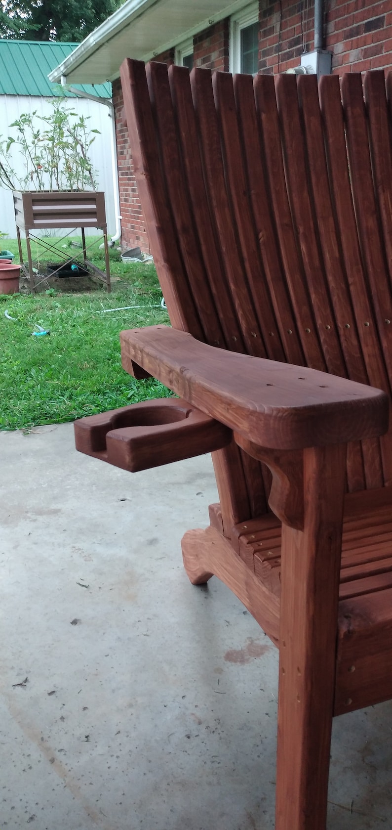 Peut inclure: Une chaise Adirondack en bois avec un porte-gobelet int&eacute;gr&eacute;. La chaise est teint&eacute;e d'une riche couleur brun rouge&acirc;tre.