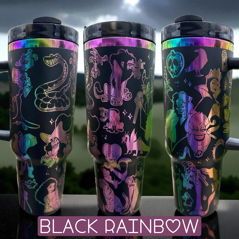 Puede incluir: Tres tazas de viaje negras con detalles iridiscentes de arco&iacute;ris. Cada taza presenta un dise&ntilde;o diferente con personajes de dibujos animados. El texto "BLACK RAINBOW" est&aacute; en la parte inferior de la imagen.