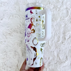 Puede incluir: Una taza de cer&aacute;mica blanca con un asa negra y el texto "But First, Coffee" en negro y negrita. La taza est&aacute; sobre una superficie blanca. La taza mide aproximadamente 10 cm de alto.