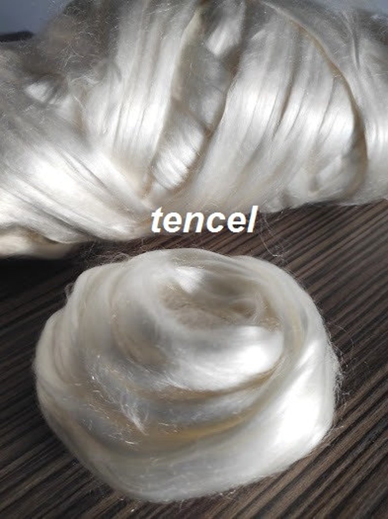 May include: A close-up of a white, fluffy, natural fiber, likely tencel, a type of rayon made from wood pulp. The fiber is soft and delicate, and it is often used in clothing and other textiles.