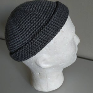 May include: A grey knitted beanie with a folded brim. The beanie is made of a soft, textured yarn.