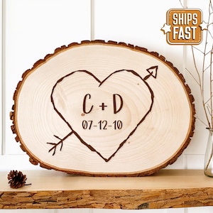 May include: A wooden heart-shaped sign with the initials "C + D" and the date "07-12-10" engraved on it. The heart is pierced by an arrow.
