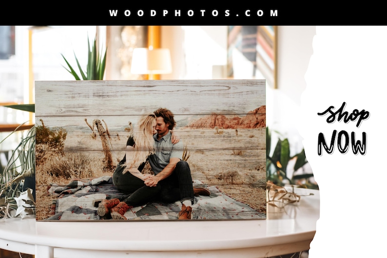 May include: A wood photo print featuring a couple embracing in a desert landscape. The print has a rustic, weathered wood background and a natural, warm color palette. The text "WOOD PHOTOS.COM" is at the top of the image and "shop NOW" is at the bottom right.
