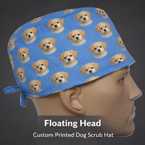 May include: A blue scrub hat featuring a repeating pattern of golden retriever puppy faces. The hat has a tie closure at the back and is designed for medical professionals. The text "Floating Head" and "Custom Printed Dog Scrub Hat" are visible.