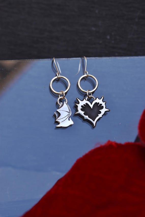 mismatched earrings with heart and bat