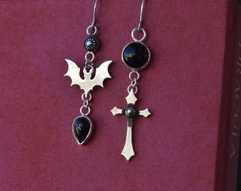 mismatched cross and bat earrings with black onyx