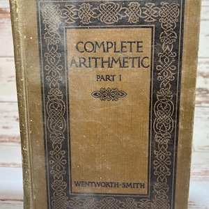 May include: A vintage book titled "COMPLETE ARITHMETIC PART 1" by Wentworth-Smith. The book has a worn, tan cover with a dark blue decorative border and text. The cover shows signs of age and use, with a faded appearance.