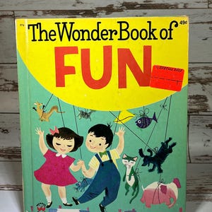 May include: A vintage children's book titled "The Wonder Book of FUN" with a yellow cover featuring a cartoon illustration of two children holding hands and swinging from a string of animals and objects. The book is priced at 49 cents.