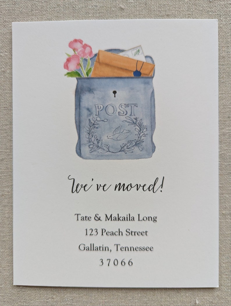 May include: A blue and white painted mailbox with a floral design and the word "POST" on the front. The mailbox is filled with envelopes and flowers. The text "We've moved!" is written below the mailbox, followed by the name "Tate & Makaila Long", the address "123 Peach Street", the city and state "Gallatin, Tennessee", and the zip code "37066".