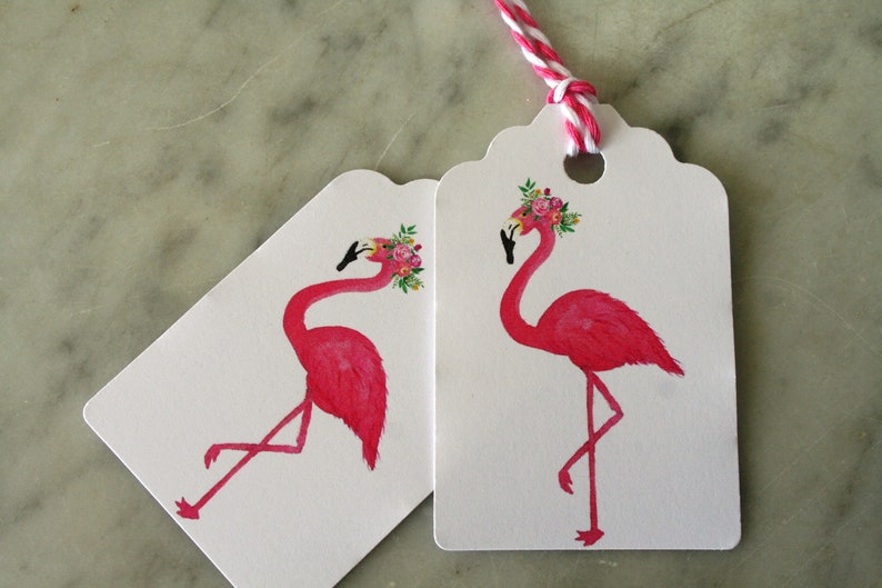 K&ouml;nnte beinhalten: Zwei rosa Flamingo-Geschenk-Etiketten mit Blumenkr&auml;nzen. Der Flamingo links schaut nach links und der Flamingo rechts schaut nach rechts. Beide Etiketten haben gewellte R&auml;nder.