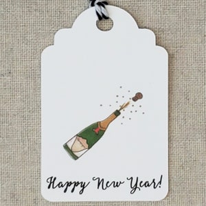 May include: White gift tag with a drawing of a champagne bottle popping with a cork flying out. The text "Happy New Year!" is written in black cursive.