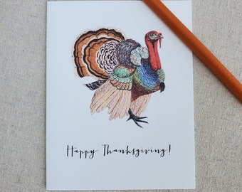 May include: A white card with a colorful illustration of a turkey with the text "Happy Thanksgiving!" printed on it.