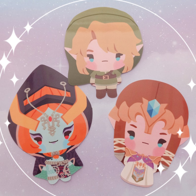 May include: Three cartoon character stickers featuring Link, Zelda, and Ganondorf from the Legend of Zelda video game series. The stickers are printed on white paper with a glossy finish.