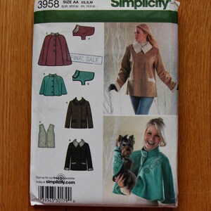 May include: Simplicity sewing pattern with illustrations of coats and jackets. Designs include a burgundy cape, a teal jacket, a brown jacket, and a black jacket with white trim. The pattern size is AA XS, S, M.