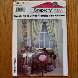 May include: A Simplicity House sewing pattern envelope, number 9801, titled Finishing Touches. The cover features an illustration of home decor items including curtains, a round table with a floral cloth, a lamp, and ruffled throw pillows.