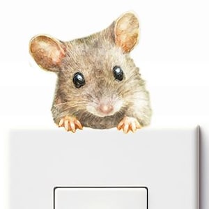Puede incluir: Una cubierta de interruptor de luz caprichosa con una ilustración detallada en acuarela de un ratón curioso asomándose por encima. El ratón tiene pelaje marrón, ojos negros grandes y pequeñas patas. La cubierta del interruptor es blanca con un interruptor rectangular.