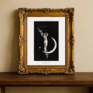 May include: A framed lithograph print featuring a black background with a white crescent moon and a figure draped in flowing fabric standing upon it. The text reads LUMINARY COLLECTION PLATE I and THE UNIVERSAL FAVORITE ORIGINAL LITHOGRAPH 1894.