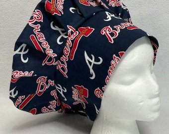 May include: A blue and red patterned scrub hat with the Atlanta Braves logo repeated throughout the fabric.