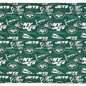 May include: Green fabric with a repeating pattern of the New York Jets logo. The logo is white with the words "NY JETS" and "Gotham City" in a white banner. The fabric is perfect for crafting projects like pillows, tote bags, and quilts.