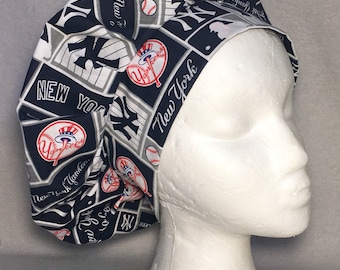 May include: A blue and white patterned surgical scrub hat with the New York Yankees logo and the words "New York Yankees" repeated throughout the design.
