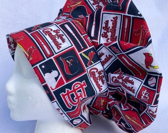 May include: A white, red, and blue fabric shower cap with a repeating pattern of St. Louis Cardinals logos, baseball bats, and baseballs.