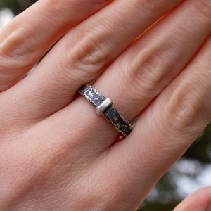 A unisex outlander-inspired hammered ring handcrafted from sterling silver with a darkened finish.