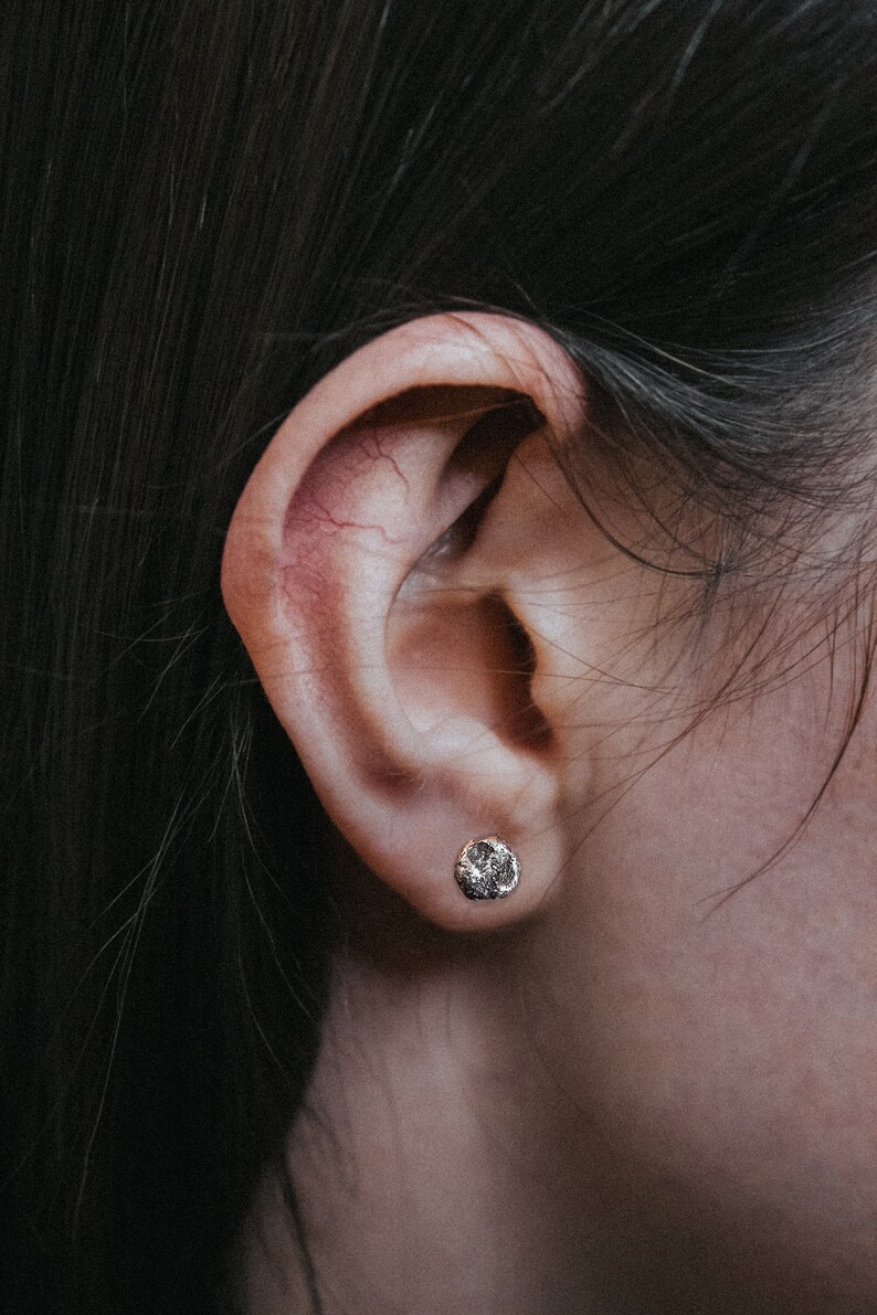 image of the moon earrings being worn in  a womans ear. Sterling silver earrings with dark patina