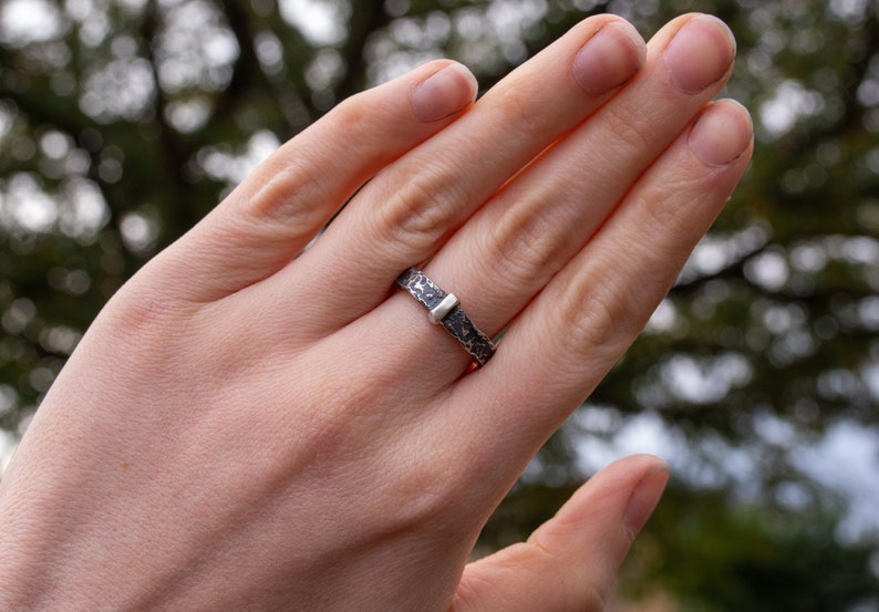 A unisex outlander-inspired hammered ring handcrafted from sterling silver with a darkened finish.