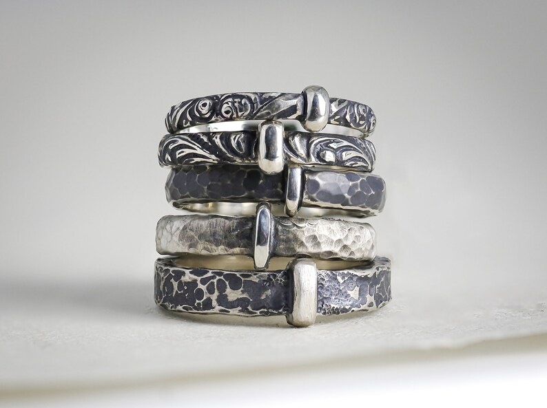 A stack of 5 popular Outlander inspired sterling silver ring styles handmade by Skolland Jewelry