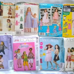 May include: A collection of children's sewing patterns from Simplicity and McCall's. The patterns feature images of dresses, tops, and skirts. The covers display illustrations of the finished garments and include the text "Sewing Patterns for Dummies".