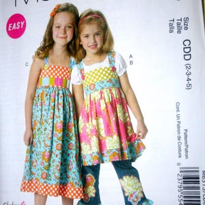 May include: McCall's sewing pattern M6313 for girls' dresses and pants. The pattern includes sizes CDD (2-3-4-5). The image shows two young girls wearing the finished garments. The pattern is labeled "EASY".
