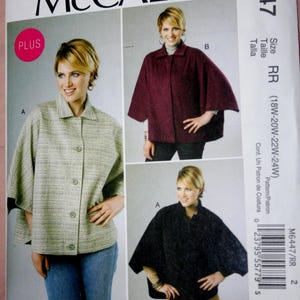 May include: McCall's sewing pattern M6447 featuring three views of a cape-style jacket. The pattern includes sizes 18W-24W. The cover shows a woman wearing the jacket in green, burgundy, and black. The pattern is by Nancy Zieman.