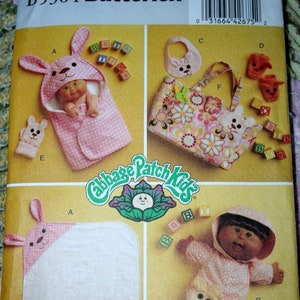 May include: A sewing pattern for Cabbage Patch Kids clothing. The pattern includes instructions for making a bunny hooded blanket, a bunny-themed outfit, a diaper bag, and a pair of booties. The pattern is from Butterick and has the number B5304/OSZ.