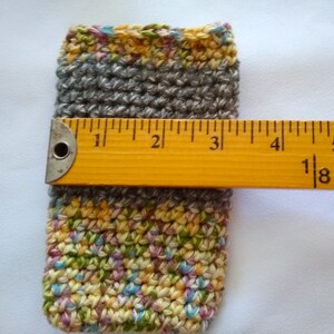 May include: A crocheted gray and multi-colored pouch with a yellow ruler measuring 4 1/8 inches.