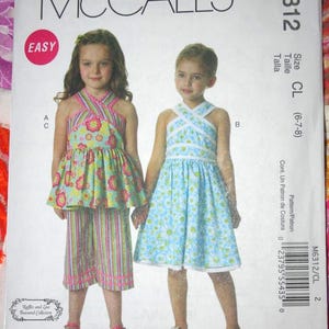 May include: A sewing pattern for a girl's dress and shorts. The pattern is for sizes 6-7-8. The pattern is called McCall's M6312 and is labeled "Easy".