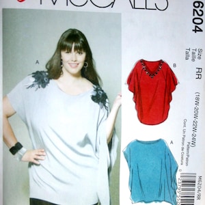 May include: McCall's sewing pattern M6204 featuring a woman modeling a light gray top with black accents. The pattern includes illustrations of a red and a blue top. Size RR (18W-20W-22W-24W).