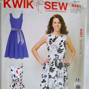 May include: Sewing pattern for a dress with a floral print and a solid blue dress. The pattern is called Kwik Sew K651 Misses' XS-S-M-L-XL.