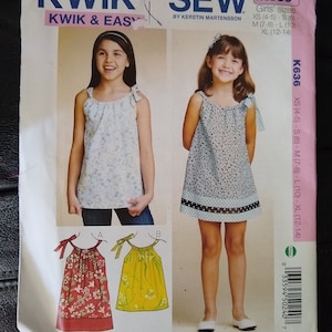 May include: Kwik Sew K636 sewing pattern for girls' tops and dresses. The pattern includes multiple views with different floral and solid fabric options. Sizes XS (4-5) to XL (12-14) are included. The cover features illustrations of the finished garments.