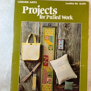 May include: A Leisure Arts craft booklet titled Projects for Pulled Work, Leaflet 96. The cover features a yellow tote bag, a long vertical wall hanging, a small rectangular framed piece, a throw pillow, and two small fabric swatches.