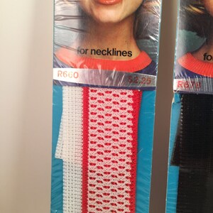 May include: Two packages of elastic trim for necklines. The trim on the left is white with a red stripe and a red and white patterned design. The trim on the right is black. The package on the left has the text "R660" and "for necklines".