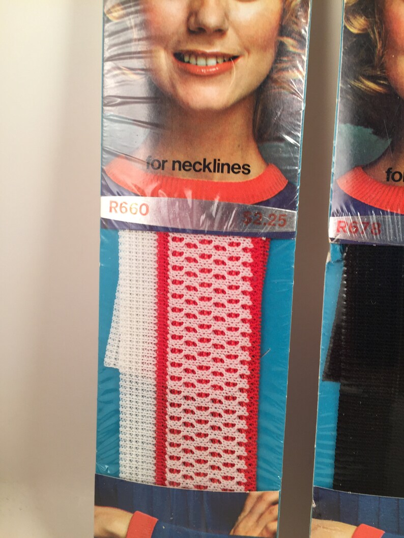 May include: Two packages of elastic trim for necklines. The trim on the left is white with a red stripe and a red and white patterned design. The trim on the right is black. The package on the left has the text "R660" and "for necklines".