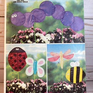 May include: A vintage sewing pattern for making garden decorations. The pattern includes instructions for making a ladybug, butterfly, bee, and a caterpillar arch. The pattern is from Butterick and is size one.