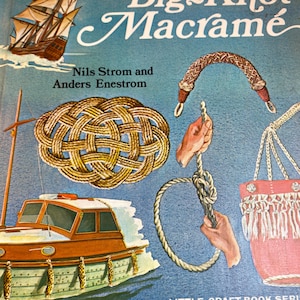 May include: A vintage book cover titled "Big Knot Macramé" with illustrations of nautical knots, a sailboat, and a motorboat. The cover is blue with white text and features the authors' names, Nils Strom and Anders Enestrom.