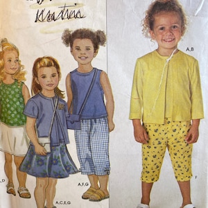 May include: A sewing pattern for children's clothing. The pattern includes instructions for making a yellow jacket, a blue and white plaid skirt, and a pair of yellow shorts with a floral print. The pattern is labeled "SUBA Kratria".