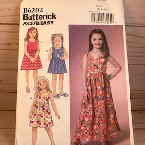 May include: A sewing pattern for a girl's dress. The pattern includes three different styles: a short-sleeved dress with a floral print, a sleeveless dress with a polka dot print, and a long sleeveless dress with a paisley print. The pattern is for sizes 2-3-4-5. The pattern is from Butterick and is labeled "Fast & Easy".