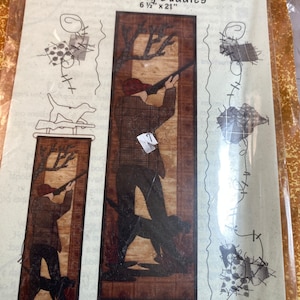 May include: A pattern for a quilt block featuring two hunters with their dogs. The block is titled "Hunting Buddies" and measures 6 1/2 inches by 21 inches. The pattern is from Patch Abilities and is labeled P102.