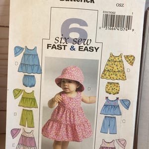 May include: A sewing pattern for six different baby outfits. The pattern includes a dress, shorts, and a hat. The pattern is called "Six Sew Fast & Easy" and is from Butterick.