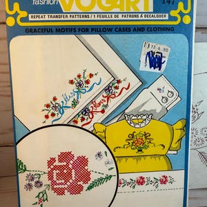May include: Vintage Vogart 147 transfer pattern packet. The packet features designs for embroidery or painting, including floral motifs for pillowcases and clothing. The packet is blue, yellow, and white.