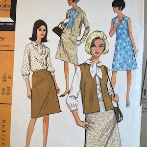 May include: Vintage sewing pattern featuring three women's outfits. The first outfit is a white blouse with brown polka dots and a brown skirt. The second outfit is a brown vest with a white blouse and a brown and white plaid skirt. The third outfit is a sleeveless blue dress with a white floral pattern.