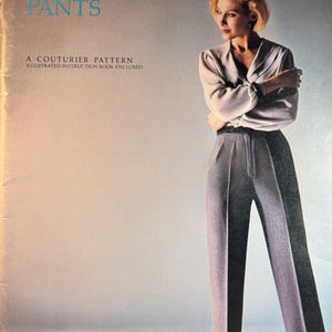 May include: A vintage sewing pattern cover with the text "Leonora's PERFECT-FIT PANTS". The cover features a woman wearing a light gray blouse and matching high-waisted pants. The pattern is described as a couturier pattern with an illustrated instruction book.